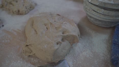 Yeast-dough-lies-on-a-table-in-a-bakery-next-to-other-baking-utensils-and-dough