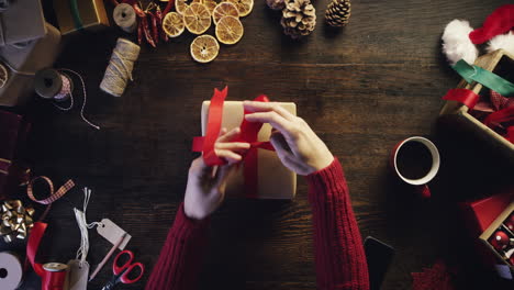 top view hands wrapping christmas presents at wooden desk from above - red epic dragon