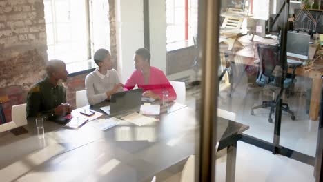 African-american-colleagues-with-laptop-on-table-discussing-work-in-office,-slow-motion