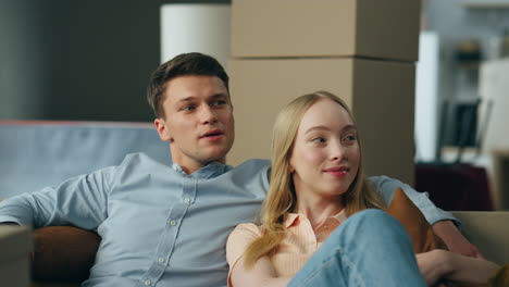 couple inspecting new home living room sitting on comfortable couch close up