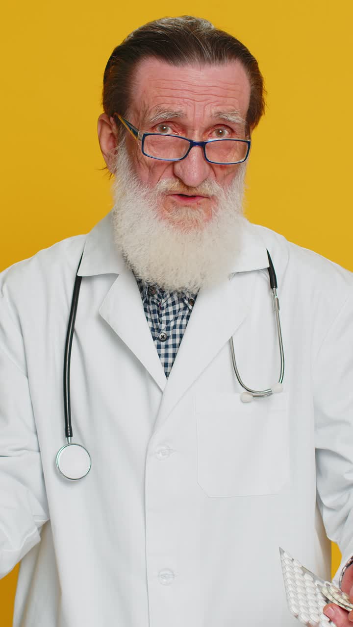 Senior doctor man show lot of tablet pills in blisters recommends drugs vitamin antibiotic treatment