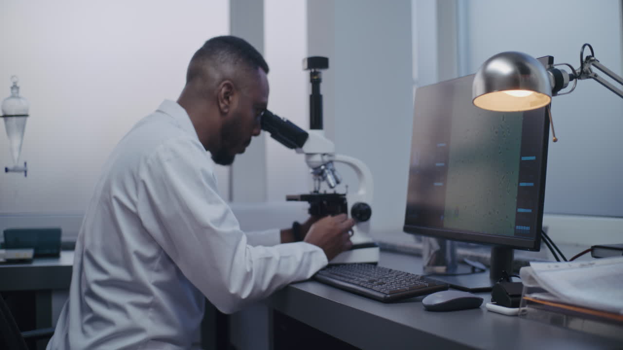 científico usando el microscopio en un laboratorio