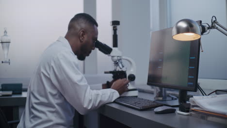 científico usando el microscopio en un laboratorio