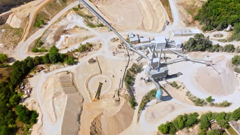 vista aérea de una cantera de piedra caliza a cielo abierto con la maquinaria y la infraestructura circundantes - toma de un dron
