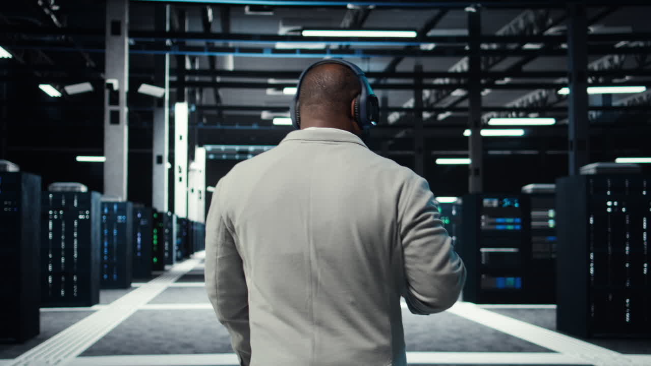 Vertical video Admin walking in data center, listening music while doing inspection