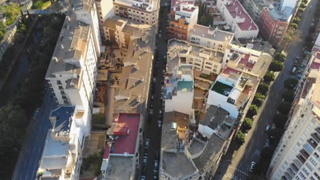 Drone-shot,-slowly-tilting-down-over-buildings-in-Palma-De-Mallorca