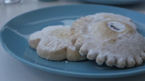 sweet powdered pastissets from menorca on a blue plate, evoking tradition and warmth