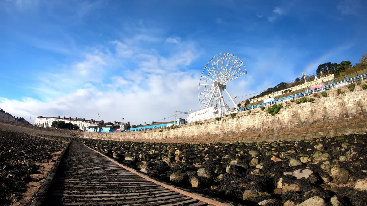 nubes que pasan por encima del desmantelamiento de la atracción de la rueda de la fortuna del muelle giratorio de llandudno al final de la temporada de turismo 2021 lapso de tiempo
