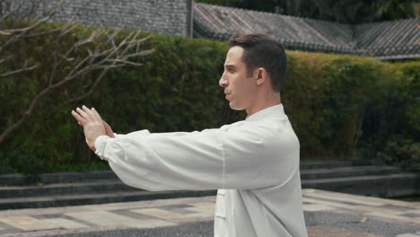 man practicing tai chi in an outdoor garden
