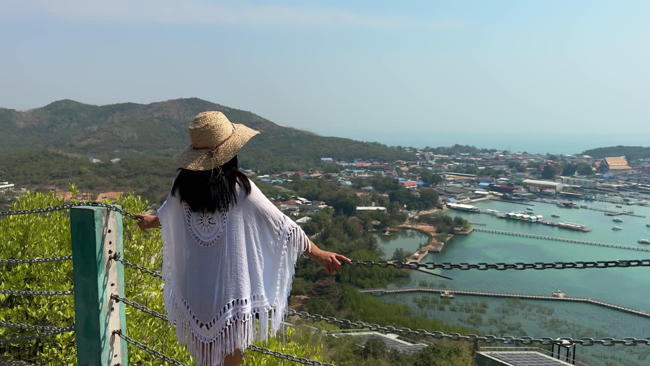 Back View Of Female Tourist In Summer Outfit Overlooking Village Of Khao Ma Cho From View Point In Chon Buri, Thailand. dolly-in shot
