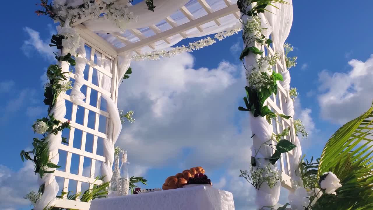 Gazebo su spiaggia tropicale per decorazione nuziale, ripresa dal basso verso l'alto dell'arco nuziale