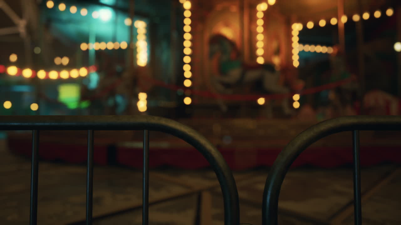An empty amusement park at night with twinkling lights and rides closed