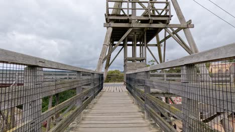 a steady walk along a wooden bridge leading to an observation tower, showcasing rustic architecture and scenic views in ballarat, australia