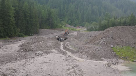 the contrast between the muddy devastation and the surrounding greenery highlights the challenges of addressing natural disasters in such pristine environments