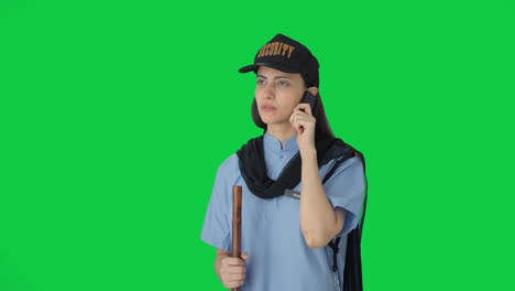 Indian-female-security-guard-talking-to-someone-on-call-Green-screen