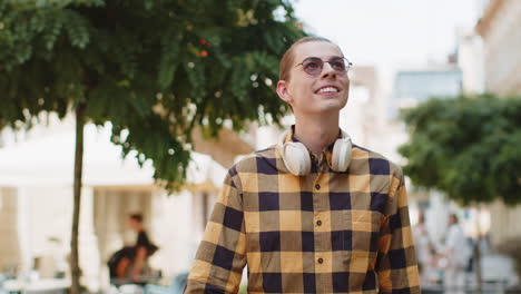 happy smiling caucasian young man tourist enjoying walking in urban city street positive good mood