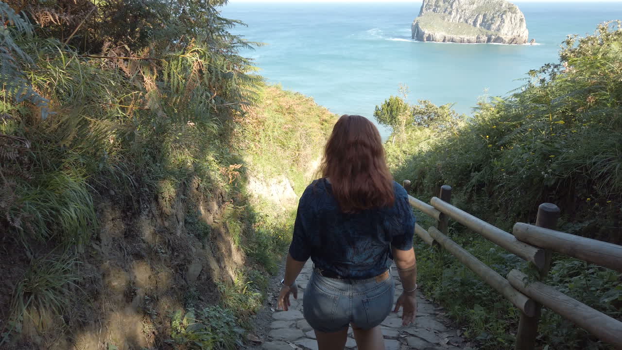 Woman on a path overlooking the sea