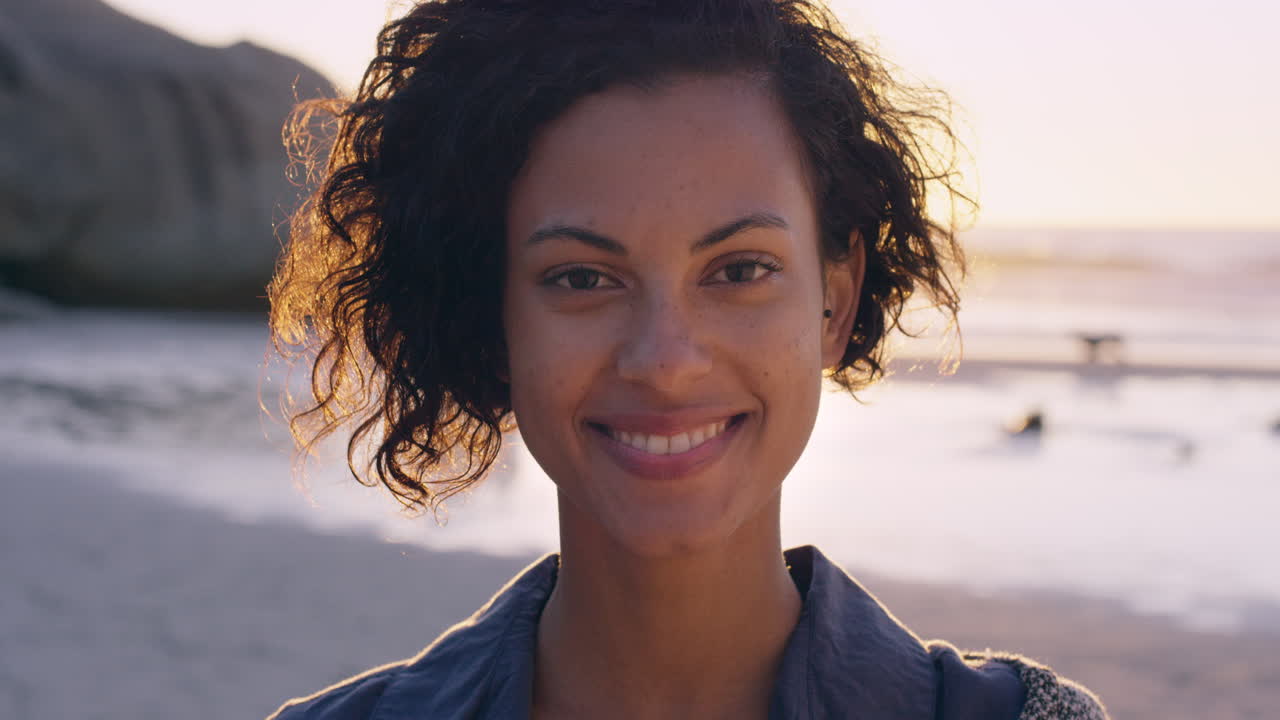 retrato de una hermosa chica sonriendo en la playa al atardecer en cámara lenta