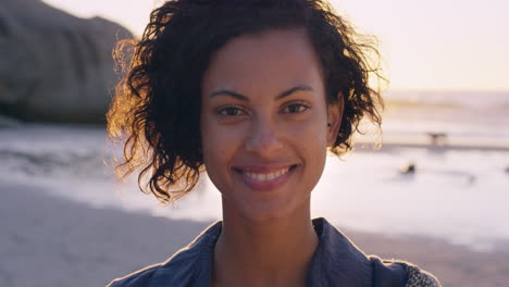 portrait of beautiful girl smiling on beach at sunset in slow motion