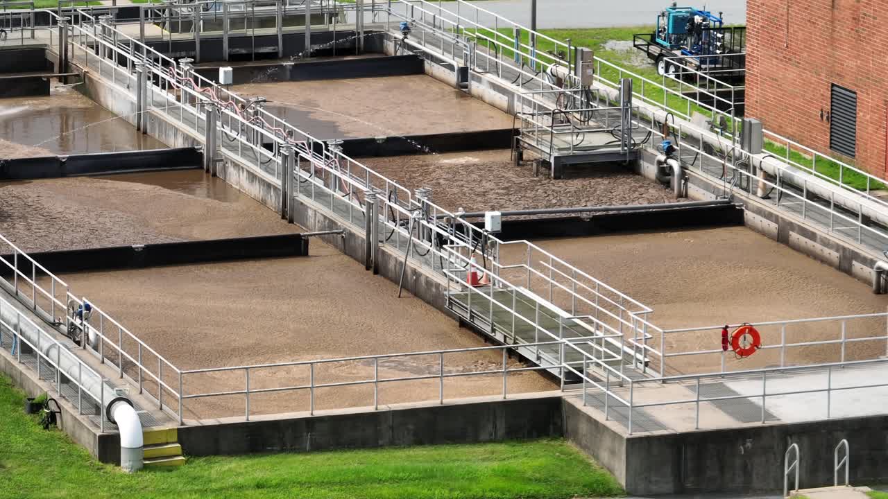 Sewage treatment plant in rural America. Large sedimentation tanks and grassy surroundings with trees. American city of Lititz, Pennsylvania