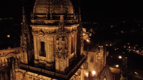 Around-the-lantern-of-the-cathedral-of-Salamanca-at-night,-aerial-close-up-view