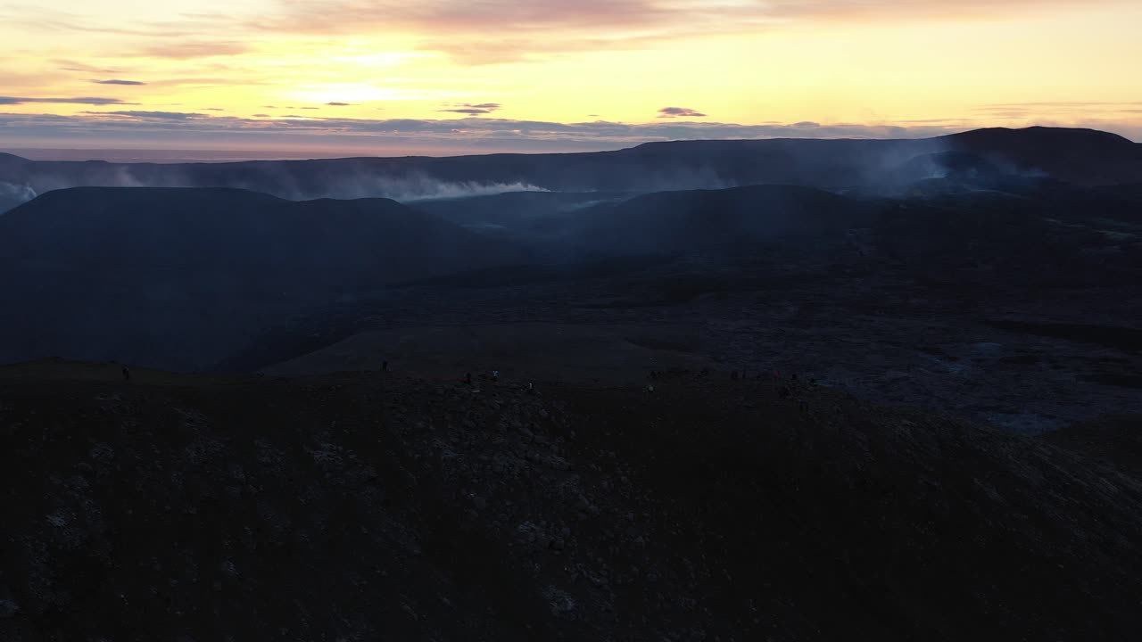 paisaje volcánico al amanecer con turistas