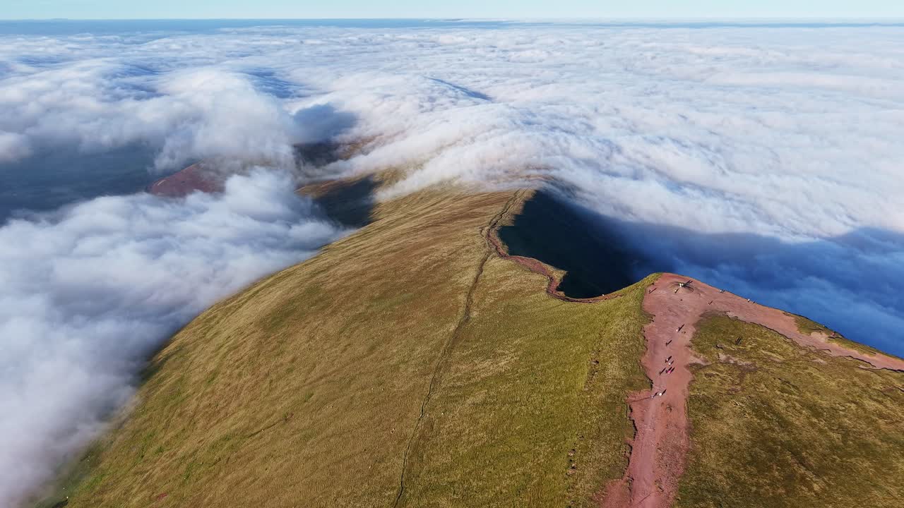 Vista aerea sorvolando la cima di Pen-y-Fan con escursionisti sopra un'inversione termica
