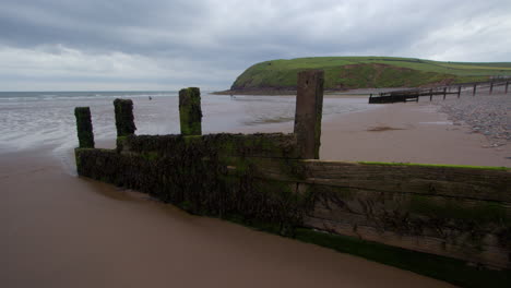 cloudy day at the beach with wooden groyne