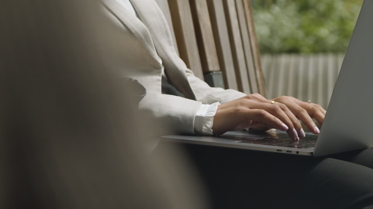 Close Up Of Businesswoman's Hands On Laptop Keyboard As She Sits Outdoors In City Gardens Working 1