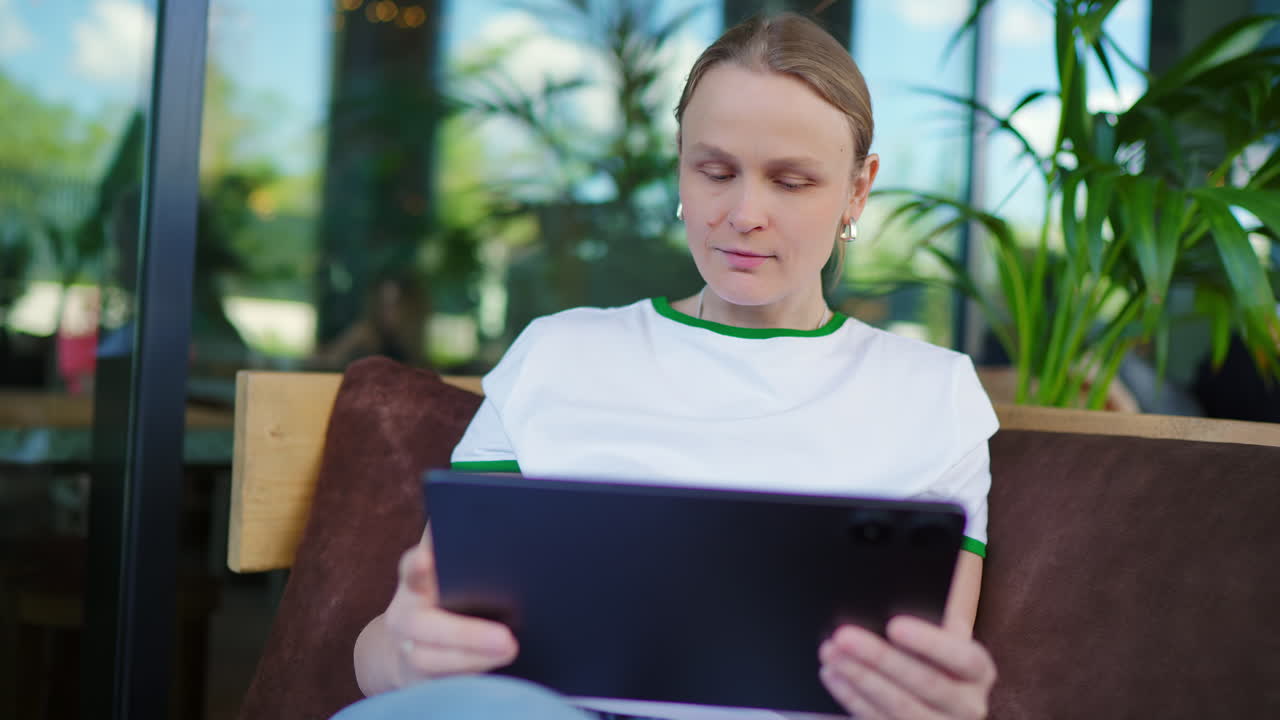 Young Woman Using Digital Tablet in Modern Cafe