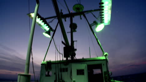 un barco de pesca enciende sus luces de inundación exteriores