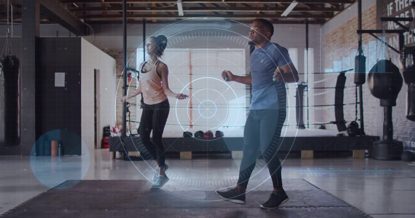 Partners rotating jump-ropes and starting synced jumps in fitness gym for cardio, HUD showing data