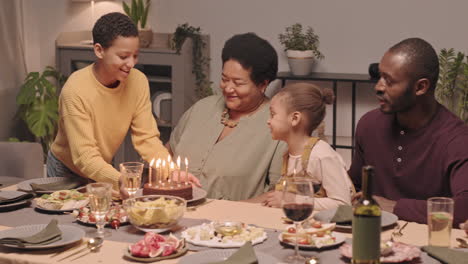 a family celebrates a birthday with cake and laughter