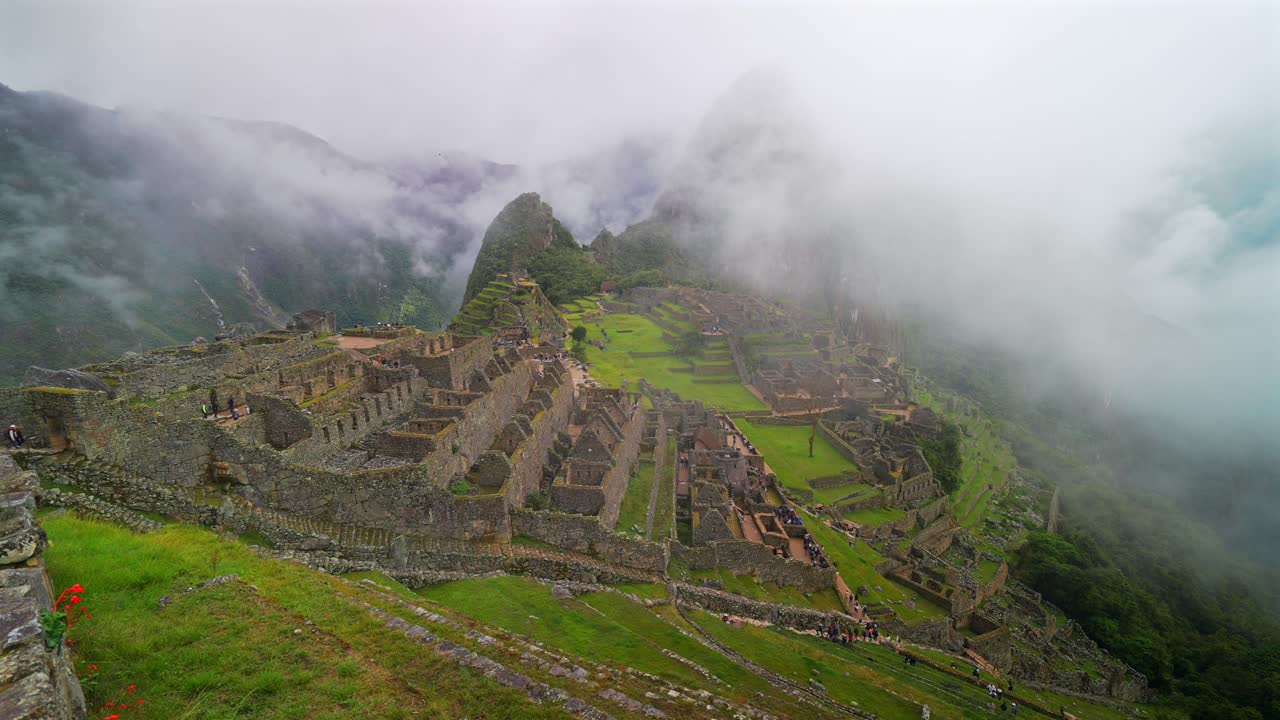 Peru's Machu Picchu landschap in de ochtend met dichte mist, wolkenlagen, Inca Trail, Tempel, Huayna Picchu Bergcircuit, Werelderfgoed, heiligdom, uitkijkterras, Peruaanse Andesgebergte, pan naar rechts.