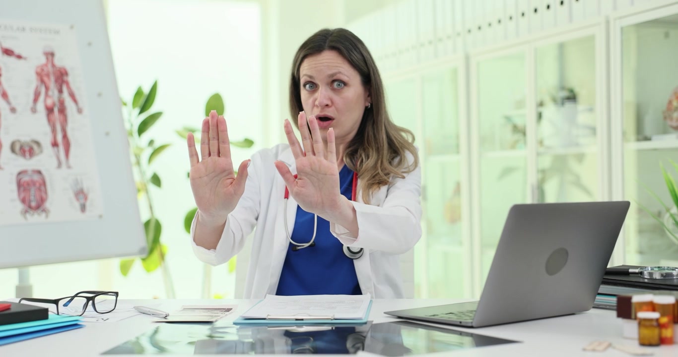 Dottoressa mostra un gesto deciso di negazione alla luminosa scrivania della clinica.