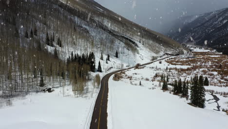 Majestätische-Winterwunderland-Berglandschaft-Bei-Schneefall,-Luftaufnahme-Nach-Vorne