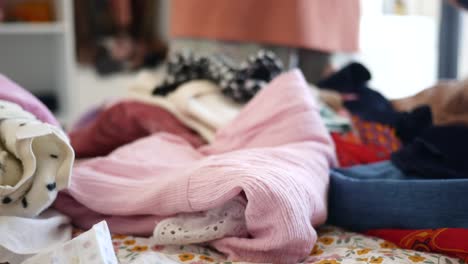 a pile of folded clothes on a bed