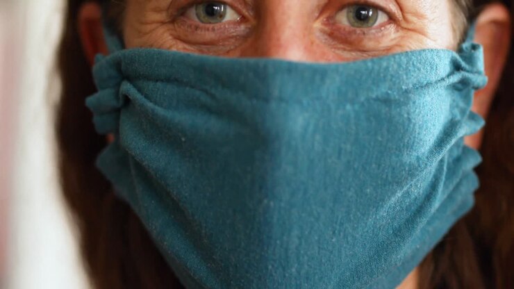 Donna caucasica che indossa una mascherina a casa