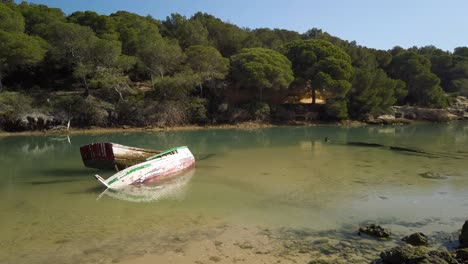 two sunken rowboats in still estuary waters with copy space on right, static