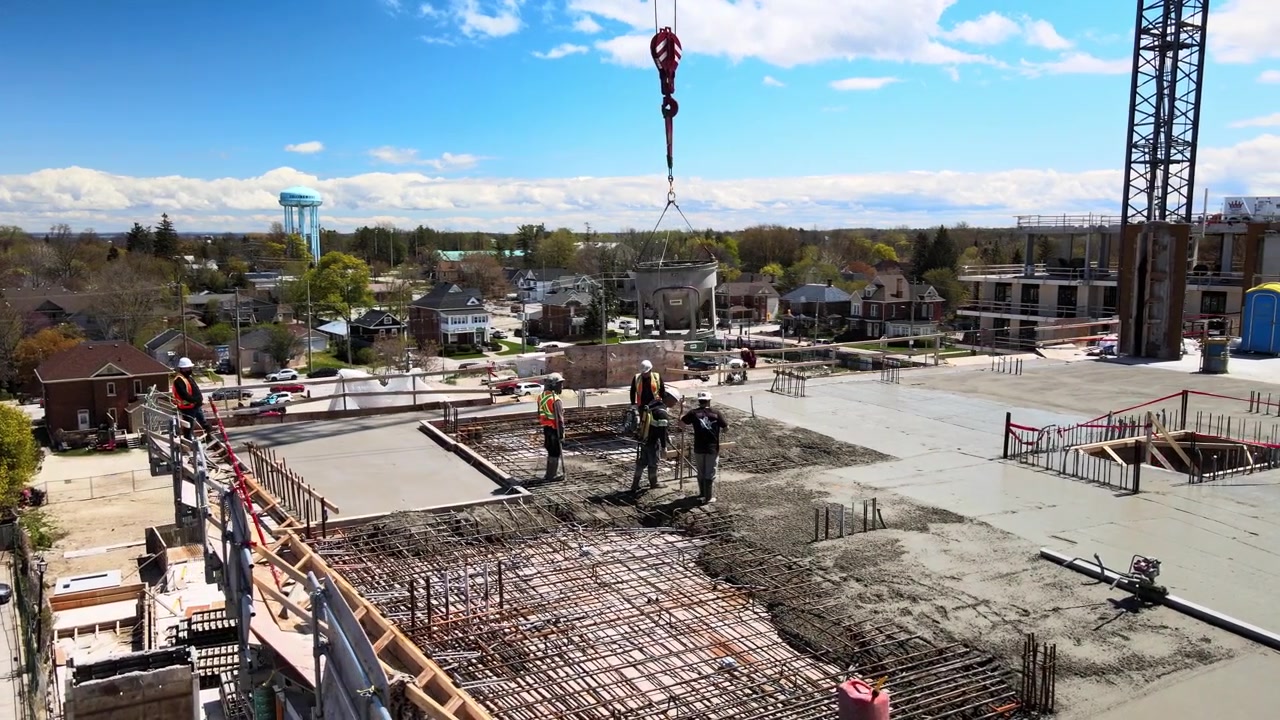 Construction workers pouring concrete on a Collingwood apartment building construction site.