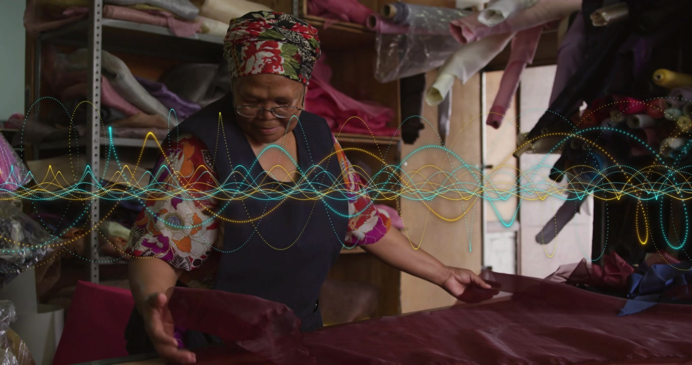 woman placing hands smoothing maroon bolt for sewing, checking edges, faint waveform crossing hands