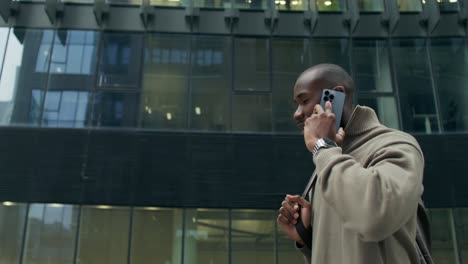 businessman talking on phone in front of a modern building