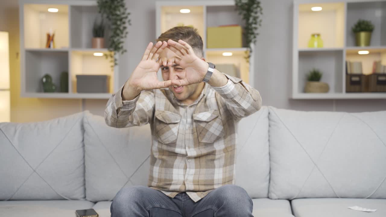 hombre haciendo el símbolo del corazón para la cámara.