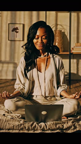 woman meditating with laptop