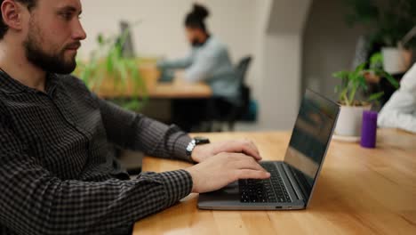 Businessman-working-on-laptop-late-in-office-with-coworkers