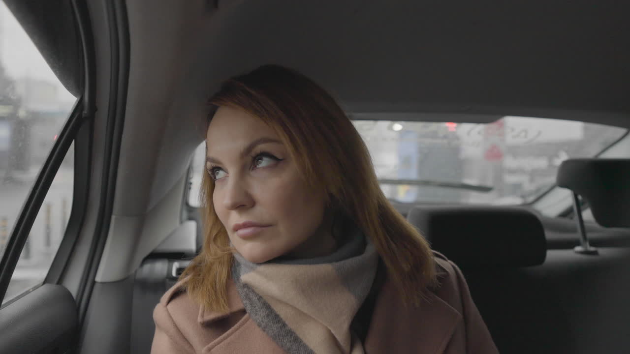 Woman looking out of a car window on a rainy day