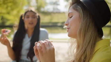 Close-up-of-woman-eating-with-her-friend