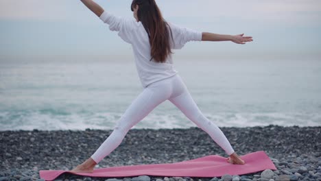 woman practicing yoga on a beach