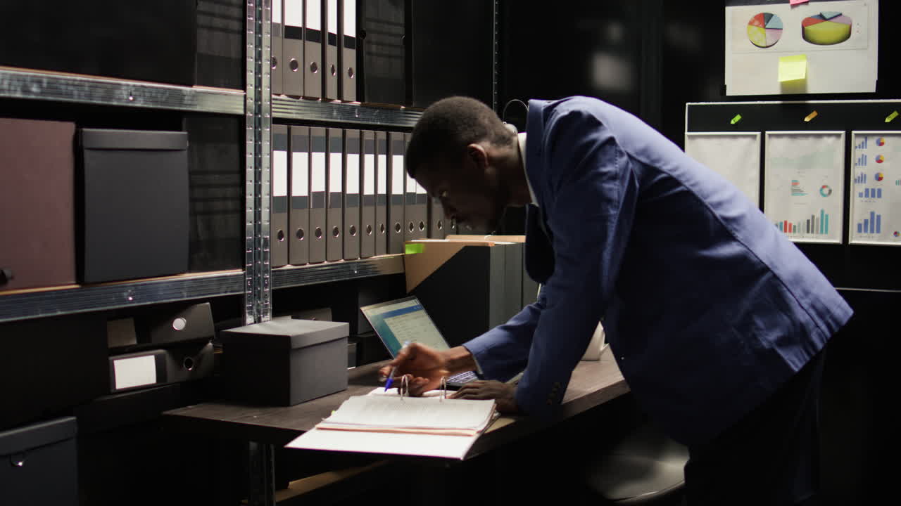 Businessman working in an office filled with filing cabinets and documents