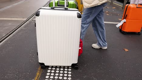 person crossing street with large suitcases